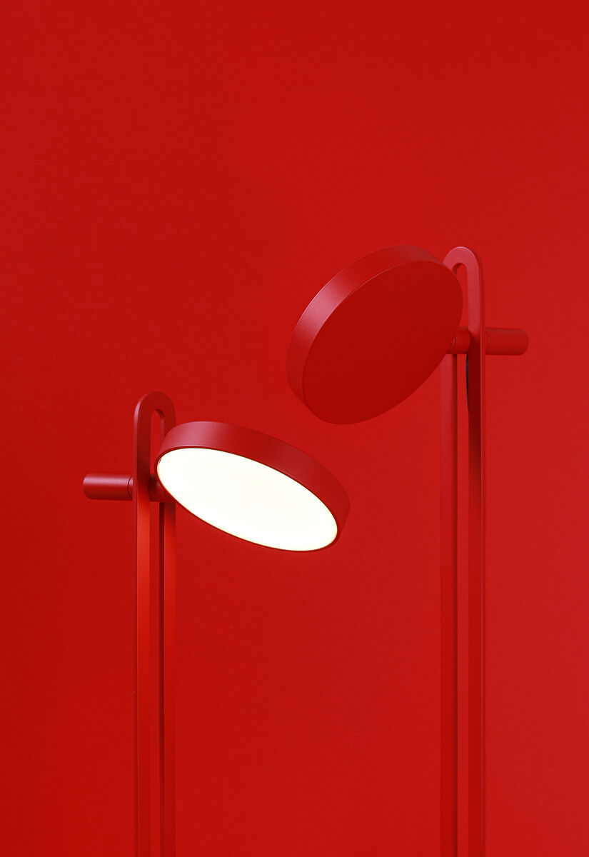 Rot grundierte Tischlampe »Echo« mit moderner LED-Beleuchtung und minimalistischer Formensprache vor einem roten Hintergrund.