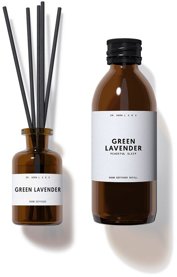 Raum Diffuser und eine Flasche ätherisches Öl in braunen Glasflaschen mit weißem Etikett auf weißem Hintergrund. Der Diffuser enthält schwarze Holzstäbchen.