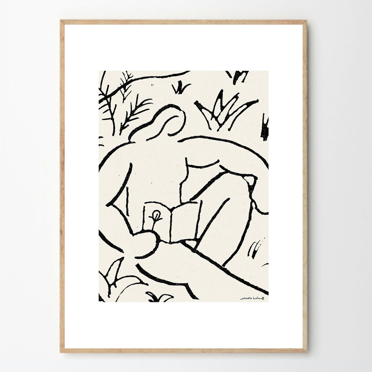 Abstrakte Illustration einer Person, die in einer natürlichen Umgebung liegt und ein Buch liest. Die Linien sind in Schwarz auf weißem Hintergrund gehalten, gerahmt in Holz.