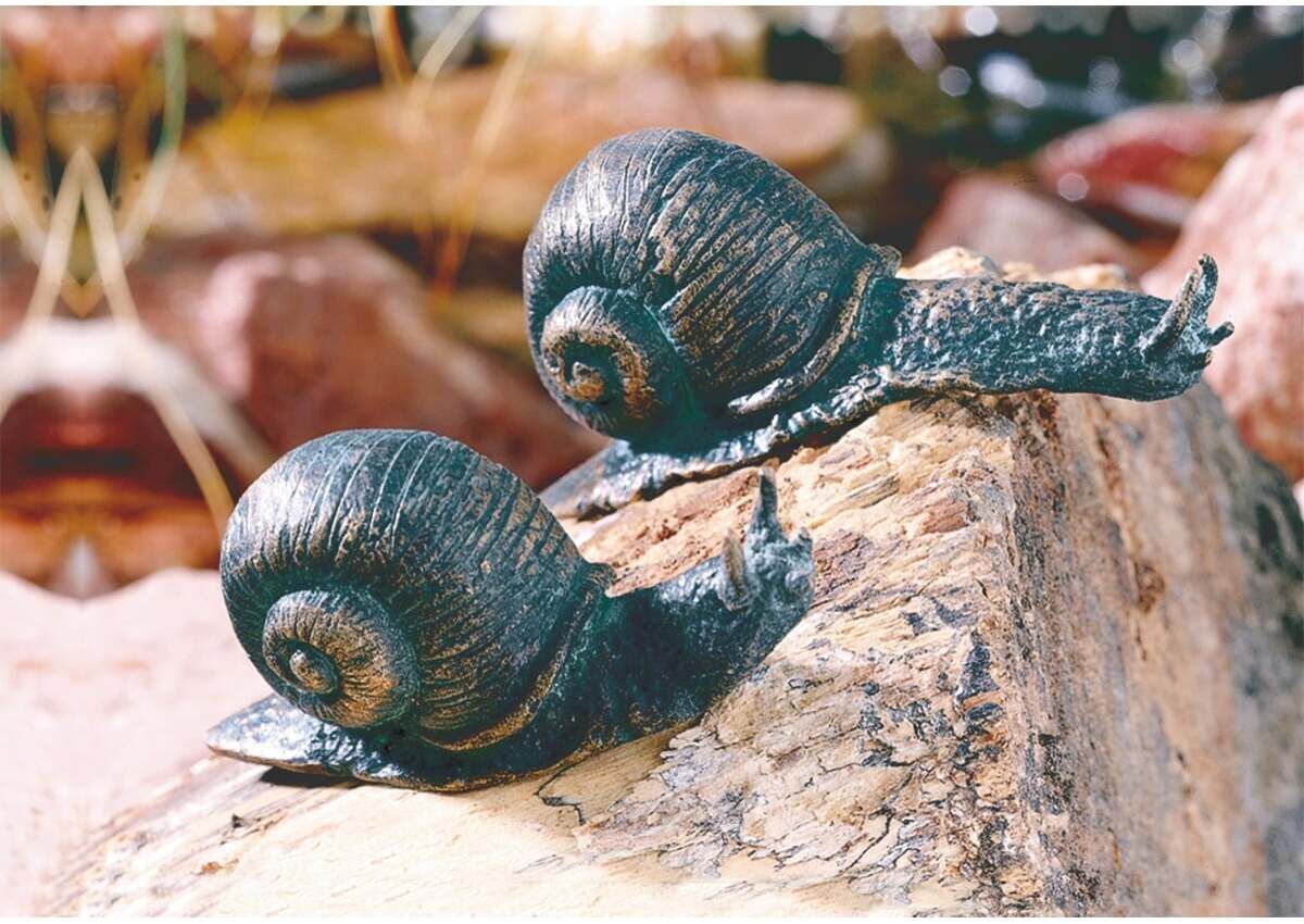 Zwei detailreiche Schnecken-Skulpturen aus Bronze in einem Set auf einem Stein platziert. Ideal für Garten- oder Terrassendekoration.