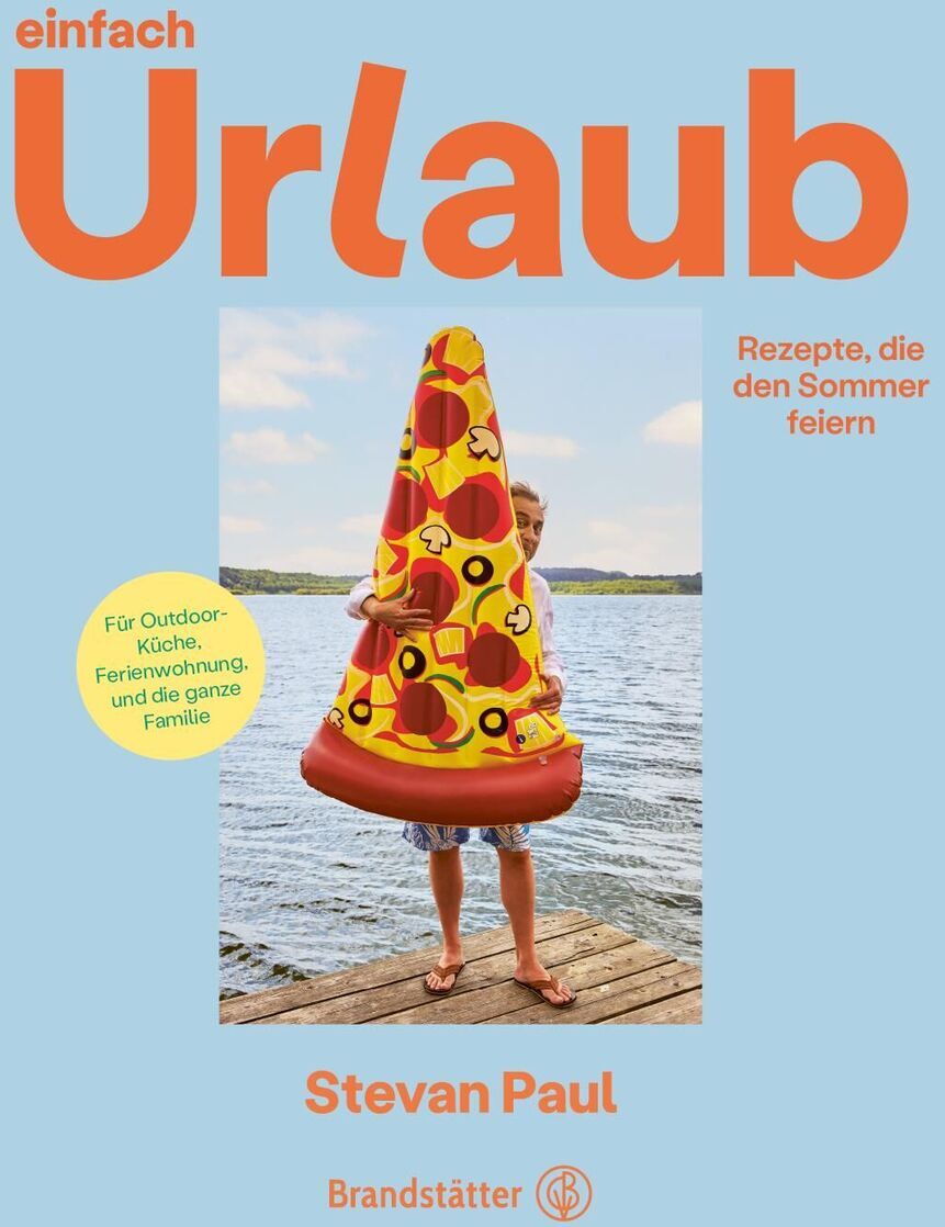 Ein Kochbuch von Stevan Paul mit dem Titel 'Einfach Urlaub'. Das Cover zeigt eine Person hinter einem aufblasbaren Pizzastück auf einem Steg über Wasser. Der Hintergrund ist hellblau und die Schrift orange und gelb.