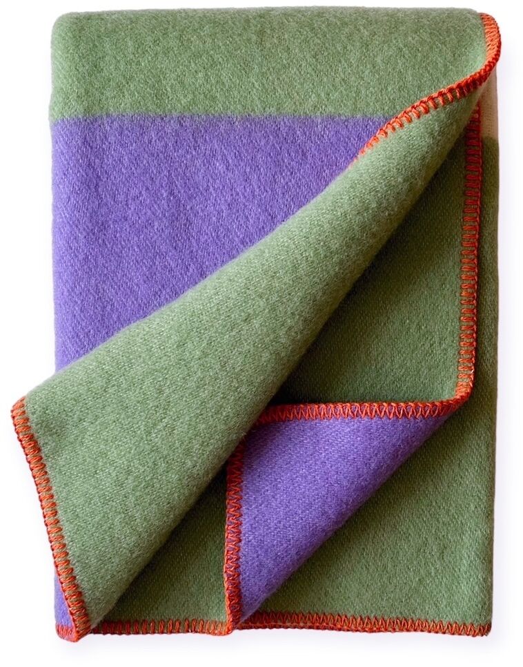 Eine Decke mit einem dreifarbigen Design: grün und lila mit einem orangen Rand. Die Decke ist aus weichem Material gefertigt und wirkt gemütlich und einladend.