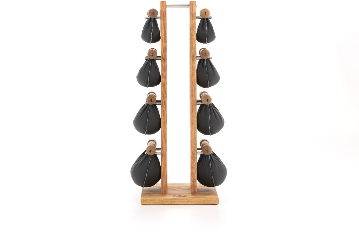 Ein Hantelturm aus Eichenholz mit mehreren Hanteln, die ergonomisch darauf angeordnet sind. Der Ständer ist minimalistisch und funktional gestaltet.