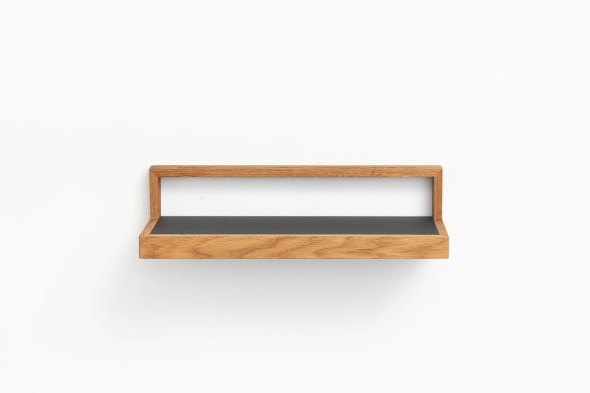 Ein schwebendes Ablagebord in anthrazit und Holzoptik vor einer weißen Wand. Das minimalistische Design eignet sich ideal zur Aufbewahrung und Dekoration in verschiedenen Räumen wie Wohnzimmer, Büro oder Flur.