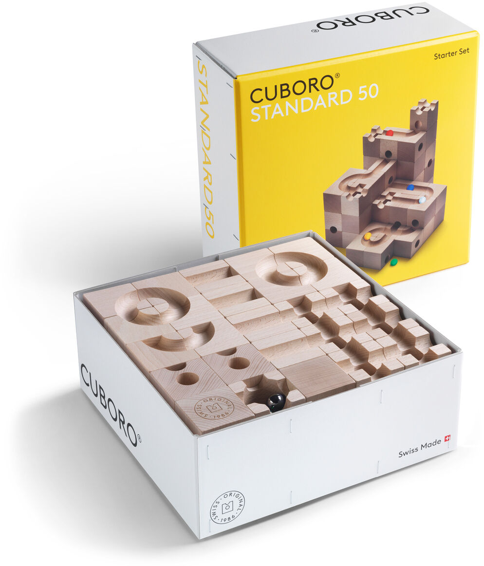 CUBORO Set »STANDARD 50 & DAS BUCH« umfasst einen Bausatz aus Holz und ein Buch. Die Verpackung des Standard 50-Sets ist gelb und zeigt das Kugelbahnsystem. Die offene Box zeigt den Holzbausatz in verschiedenen Formen.