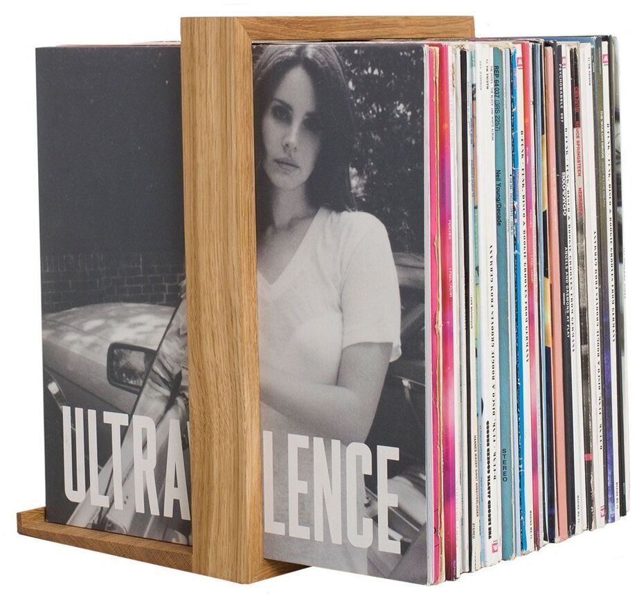 Ein Plattenständer aus Holz mit dem Namen »B-Seite«, der eine Sammlung von Schallplatten, inklusive Lana Del Reys Album »Ultraviolence«, organisiert hält. Der Ständer ist einfach und modern gestaltet.