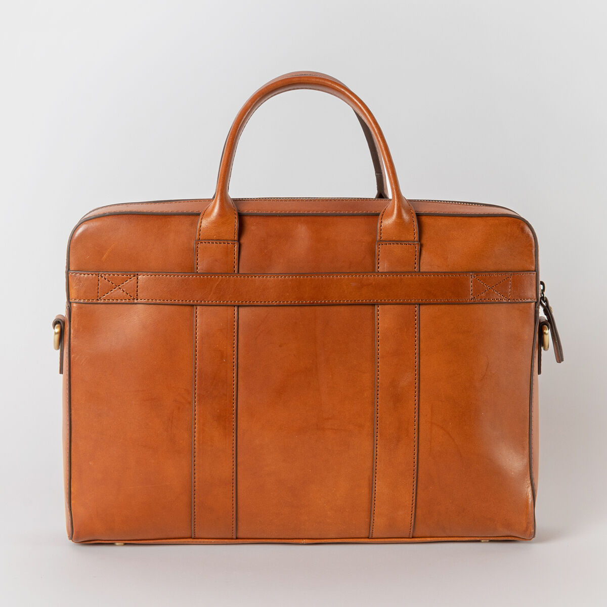 Eine elegante Ledertasche namens Harvey in hellbraun. Die Tasche hat zwei kurze Henkel und ist minimalistisch im Design.