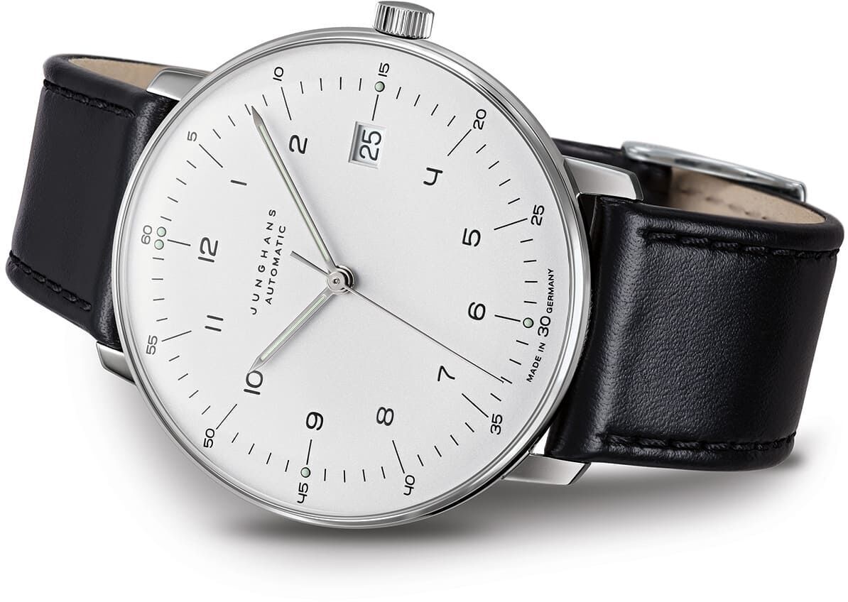 Eine Junghans-Uhr Max Bill Automatic mit einem weißen Zifferblatt, schwarzen Ziffern, einem Datum auf drei Uhr und einem schwarzen Lederarmband.