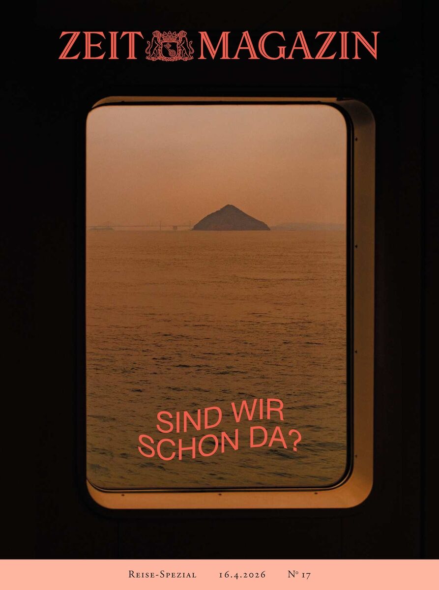 Titelbild der ZEIT Magazin Ausgabe 17/2026: Dunkler Rahmen eines Schiffsfensters, durch das man auf ruhiges Wasser und eine abgelegene Insel blickt. Warme Orangetöne dominieren die Szene. Der Schriftzug „Sind wir schon da?“ steht über dem Wasser. Reise-Spezial und Ausgabedaten am unteren Rand.
