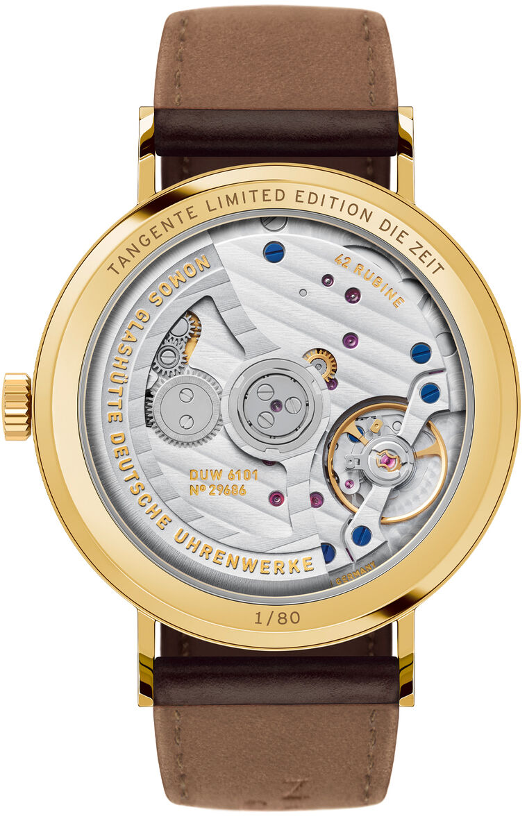 Exklusive Armbanduhr ZEITmagazin-Sonderedition Tangente Gold neomatik 38 Update von NOMOS Glashütte mit goldfarbenem Gehäuse, gläsernem Sichtboden auf der Rückseite und sichtbarem Automatikwerk. Dunkelbraunes Lederarmband, feine Mechanik, limitierte Edition.