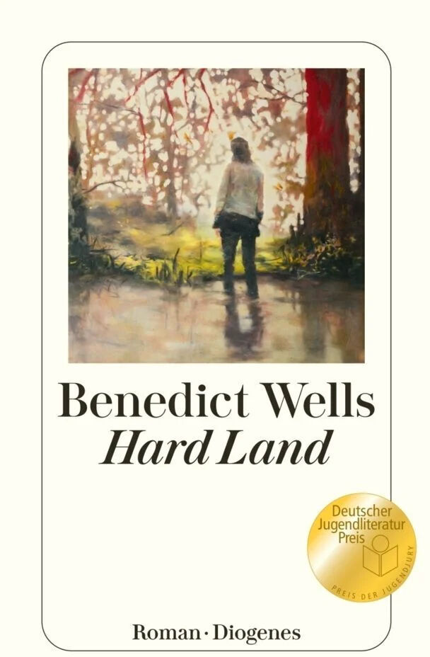 Cover des Buches 'Hard Land' von Benedict Wells, veröffentlicht vom Diogenes Verlag, zeigt eine stehende Person vor einer malerischen Landschaft mit Bäumen und Lichtreflexionen im Wasser. Ein Sticker für den 'Deutscher Jugendliteraturpreis' ist in der unteren rechten Ecke angebracht.