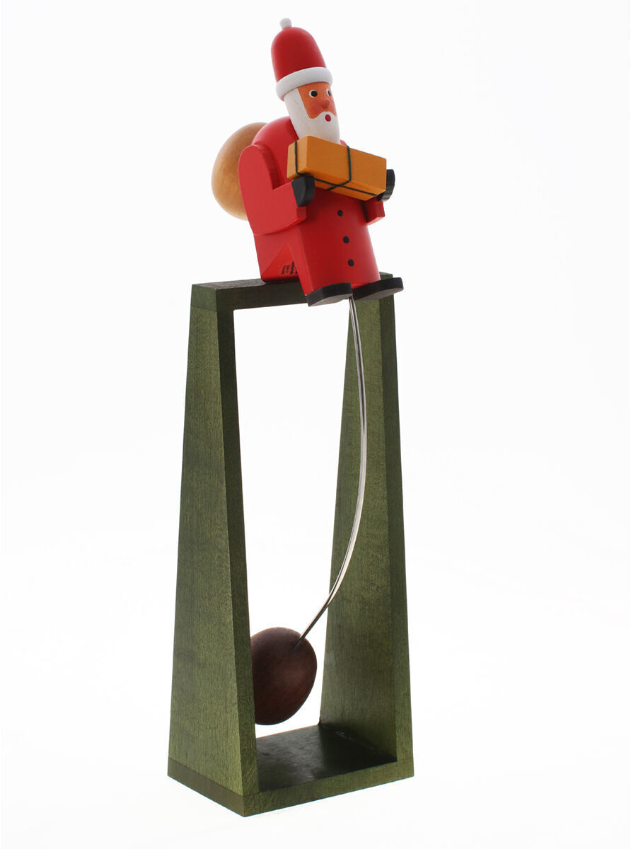 Eine weihnachtliche Dekoration zeigt einen schaukelnden Weihnachtsmann auf einer Holzplattform. Der Weihnachtsmann trägt traditionelle rote Kleidung und einen Sack auf dem Rücken. Die Konstruktion ist hauptsächlich in grünen und braunen Farbtönen gehalten. Perfekt als Raumdekoration für die Weihnachtszeit.