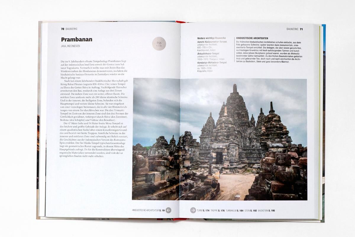 Ein Buch mit dem Titel 'Eine kurze Geschichte der Architektur' von Susie Hodge. Das Buch ist auf einer hellen Oberfläche aufgeschlagen und zeigt eine Doppelseite mit einer Beschreibung und einem Bild des Prambanan-Tempelkomplexes. Die Seite links enthält Text, während die rechte Seite ein großes Bild des Tempels in Indonesien zeigt.
