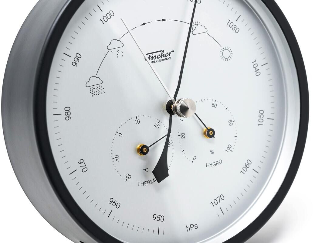 Abgebildet ist die ZEIT Sonderedition »Wetterstation Edelstahl«. Die Wetterstation ist rund, hat ein schwarzes Gehäuse und ein weißes Zifferblatt mit diversen Messinstrumenten und Symbolen zur Wettervorhersage. In der Mitte befinden sich drei Zeiger für das Barometer, Hygrometer und Thermometer. Die Zahlen und Symbole sind schwarz.