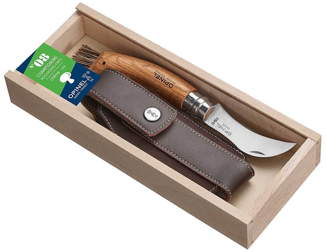 Ein Pilzmesser mit Etui. Das Messer hat eine gebogene Edelstahlklinge und einen Griff aus Holz. Es ist in einem braunen Lederetui untergebracht und wird in einer hölzernen Schachtel präsentiert.