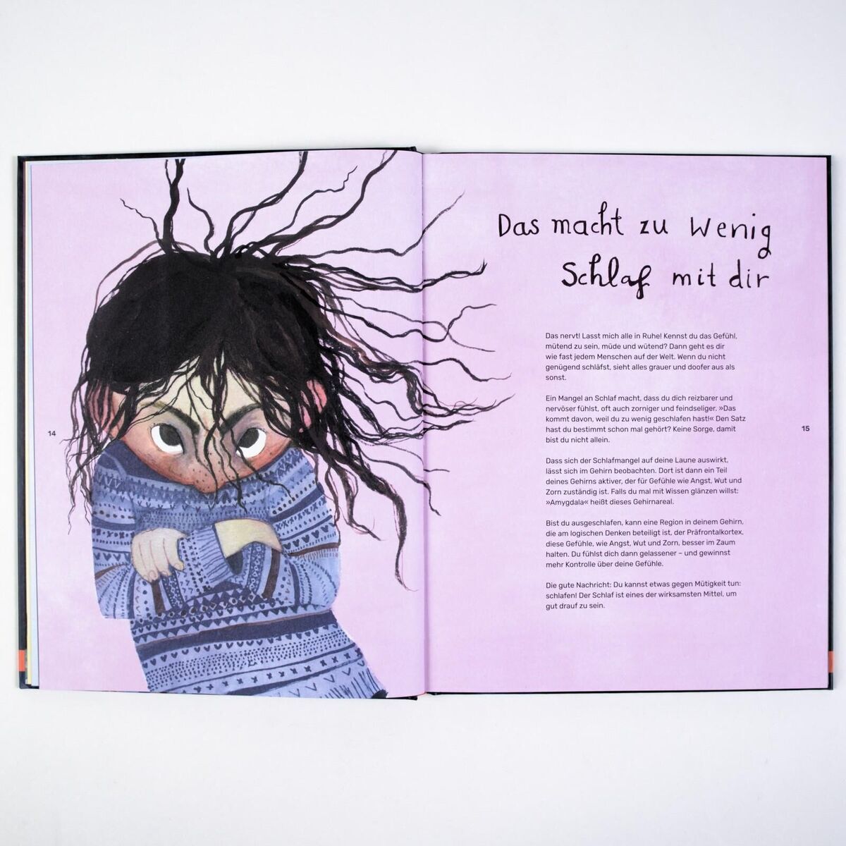 Geöffnetes Kinderbuch mit dem Titel 'Wenn wir schlafen' von Andrea Böhnke. Links eine Illustration eines Kindes mit schwarzen, zerzausten Haaren und einem blauen Pullover. Der Hintergrund ist lila. Rechts Text in deutscher Sprache mit der Überschrift 'Das macht zu wenig Schlaf mit dir'.