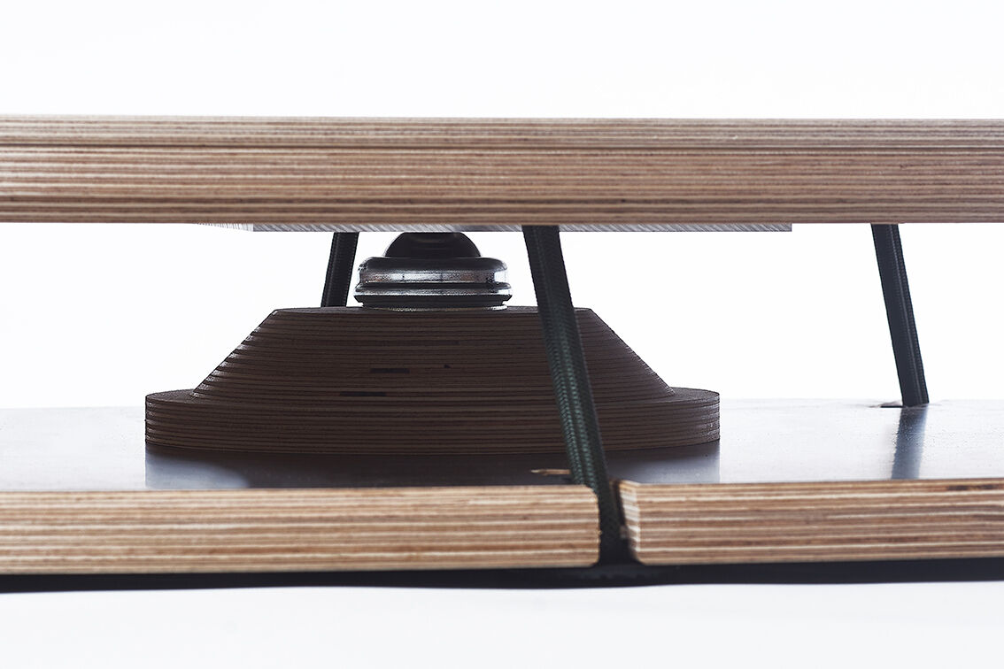 Ein Sensoboard aus Holz und Metall, ideal für Balance-Training und Fitnessübungen. Es besteht aus mehreren Schichten aus Sperrholz und besitzt eine mittige Metallverbindung, die für instabile Bewegung sorgt. Perfekt für sportlich Interessierte.