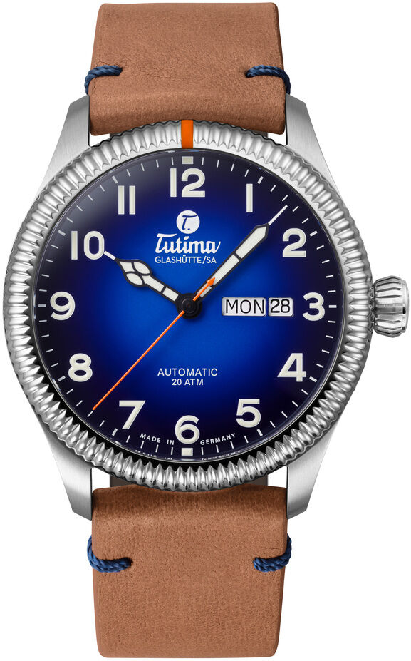 Edle Armbanduhr ZEIT-Sonderedition "Grand Flieger Classic Automatic" von Tutima Glashütte mit blauem Zifferblatt, hellbraunem Lederarmband und silbernem Edelstahlgehäuse. Sichtboden, nummeriert, limitierte Auflage, moderne arabische Ziffern und orangefarbene Markierung bei 12 Uhr.