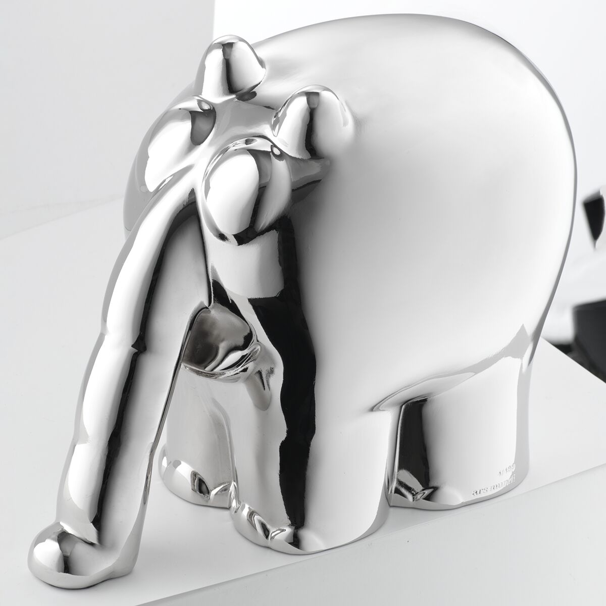 Metallisch-silberne Skulptur eines stilisierten, Comic-artigen Elefanten namens "Ottifant", entworfen von Otto Waalkes. Die Oberfläche glänzt stark, das Objekt steht auf einer hellen, glatten Fläche. Details wie Beine, Rüssel und Augen sind abstrahiert dargestellt.