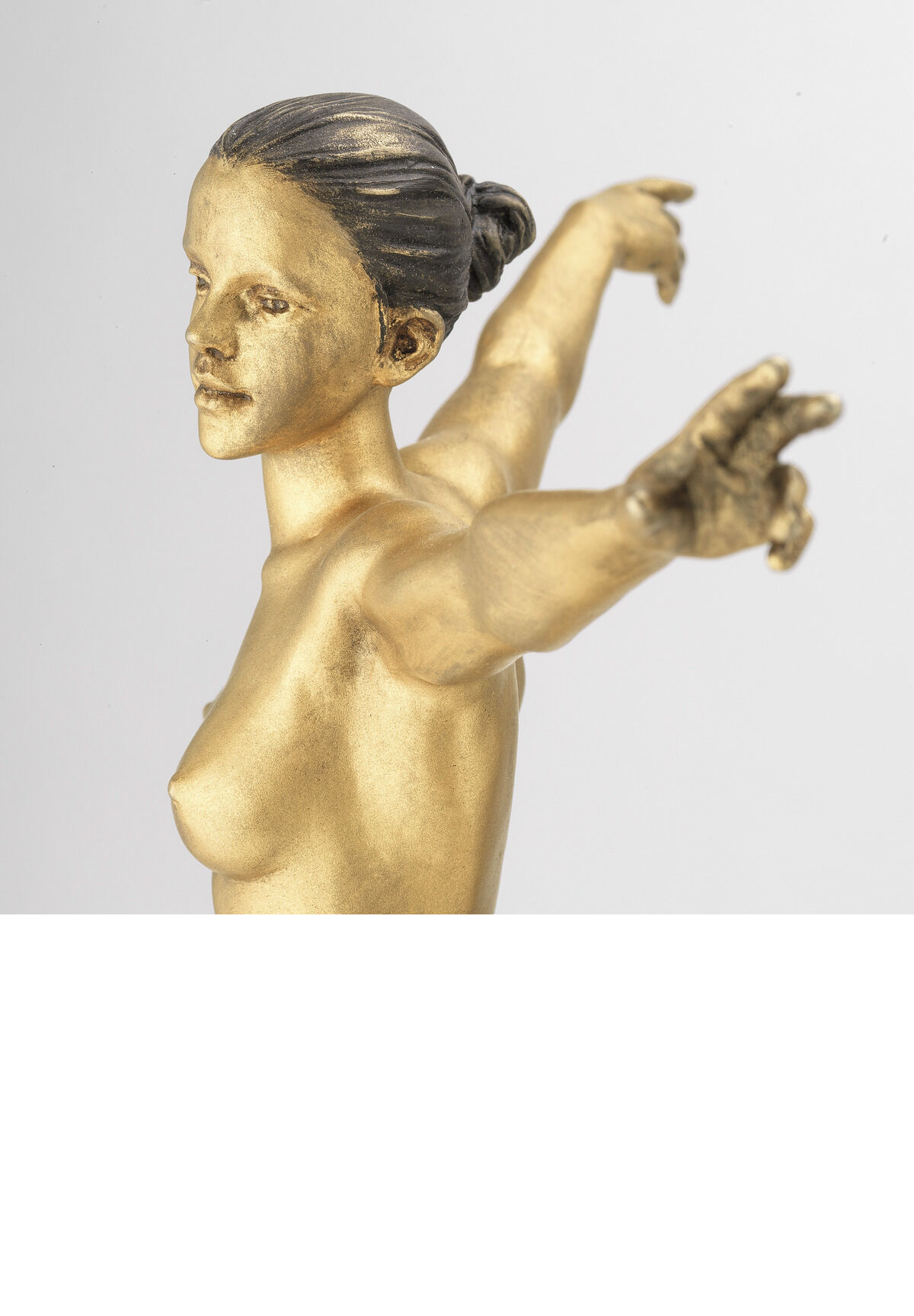 Eine goldfarbene Skulptur einer nackten Frau mit ausgebreiteten Armen, geschaffen von Leo Wirth im Jahr 2021. Die Figur steht aufrecht und vermittelt den Eindruck von Freiheit. Detaillierte Körperlinien und eine glatte Oberfläche kennzeichnen die Arbeit.