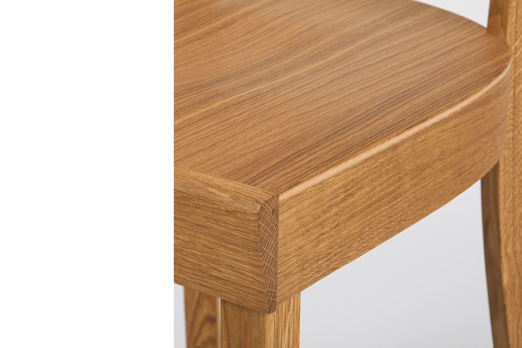 Detailaufnahme eines hochwertigen Küchenstuhls aus geölter Eiche der ZEIT Sonderedition 'Frankfurter Küchenstuhl'. Sichtbare Maserung und natürliche Holzfarbe betonen das minimalistische, zeitlose Design.