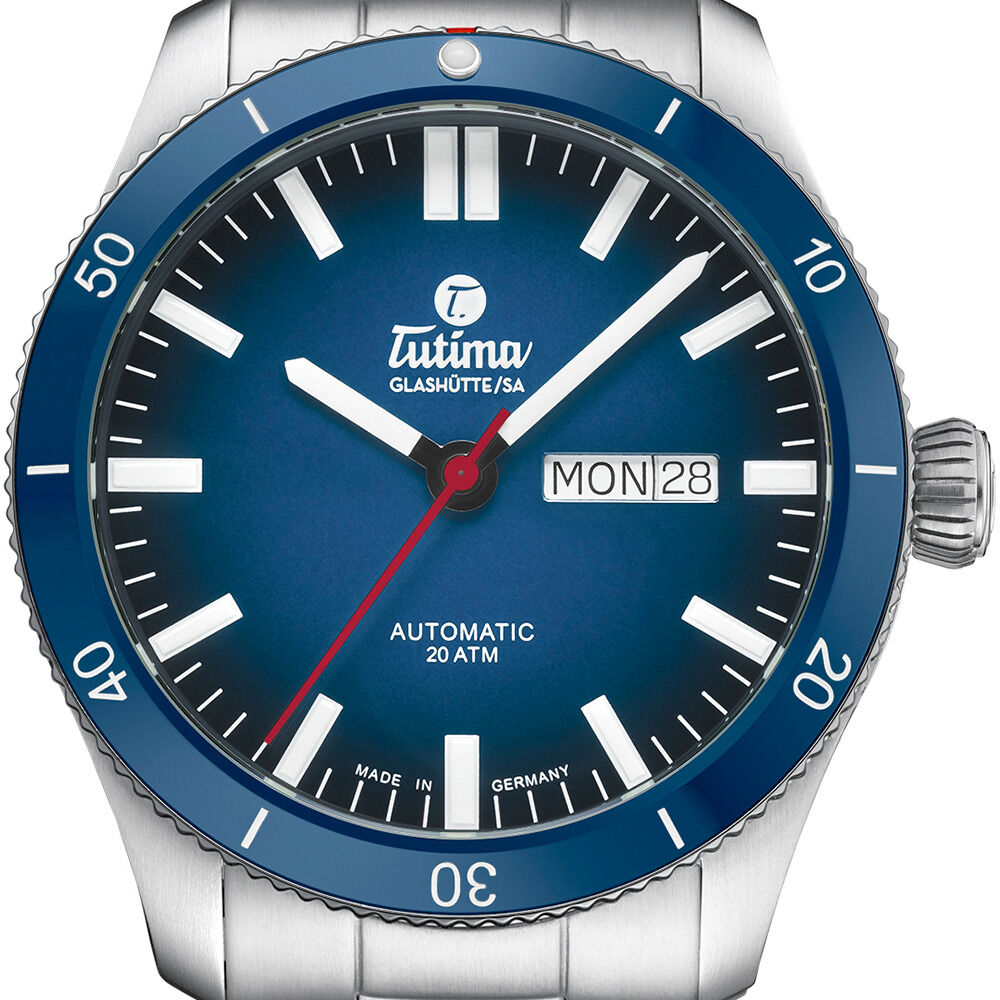 Detailreiche Aufnahme der ZEIT-Sonderedition Automatikuhr »Grand Flieger Airport Automatic« von Tutima Glashütte. Edelstahlgehäuse und -armband, blaues Zifferblatt mit Farbverlauf, weiße Indizes, rote Sekunde, Tag- und Datumsanzeige, drehbare Keramiklünette.