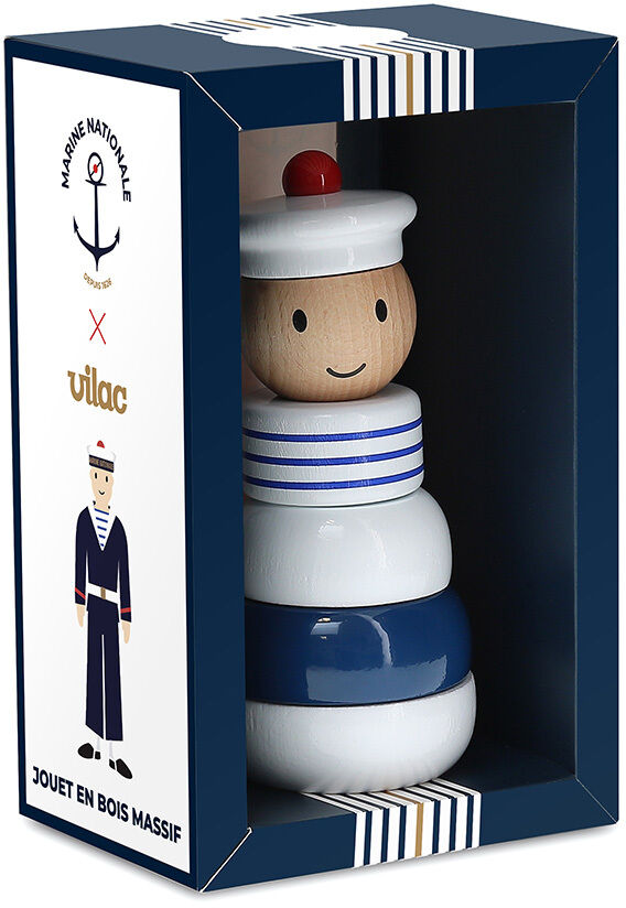 Eine Holzstapelfigur mit einem maritimen Thema in einer Box, die blau-weiße und rote Farbtöne aufweist. Der Deckel der Box zeigt eine stilisierte Abbildung eines Matrosen.