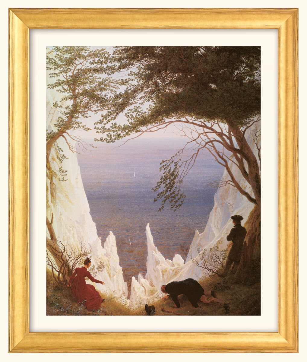 Ein Gemälde von Caspar David Friedrich zeigt eine majestätische Landschaft mit hohen, weißen Klippen, die von grünen Bäumen umrahmt werden, Blick auf das blaue Meer und einen rosa-blauen Himmel. Zwei Menschen sitzen am Rand, während eine weitere Figur steht. Der goldene Rahmen gibt dem Bild einen klassischen Touch.