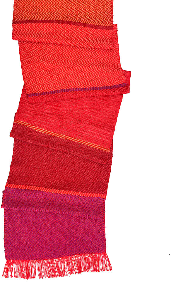 Ein Seidenschal in den Farben Rot, Orange und Pink, der in mehreren Schichten gefaltet ist und Fransen an den Enden hat. Ein stilvolles und buntes Accessoire, das sowohl für festliche als auch alltägliche Anlässe geeignet ist. Perfekt für Herbst- und Wintermode.