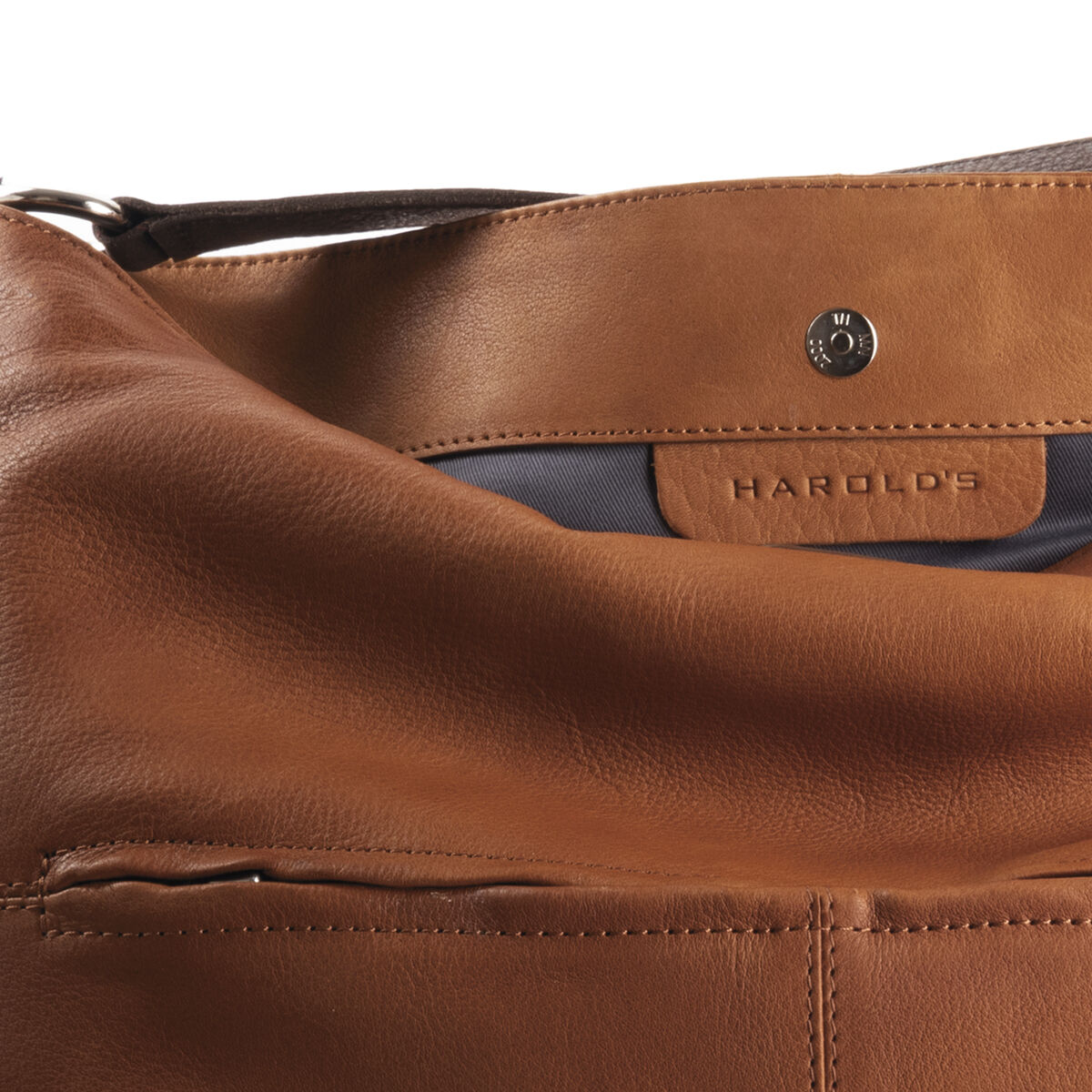 Die Beuteltasche »Chaza Pouch Upend« von Harold's ist eine braune Ledertasche mit einem minimalistischen Design. Sie verfügt über silberfarbene Details und einen verstellbaren Schulterriemen. Innen ist sie mit einem grauen Stoff ausgekleidet und besitzt einen Magnetverschluss. Eine elegante und hochwertige Tasche, perfekt für den Alltag oder besondere Anlässe.