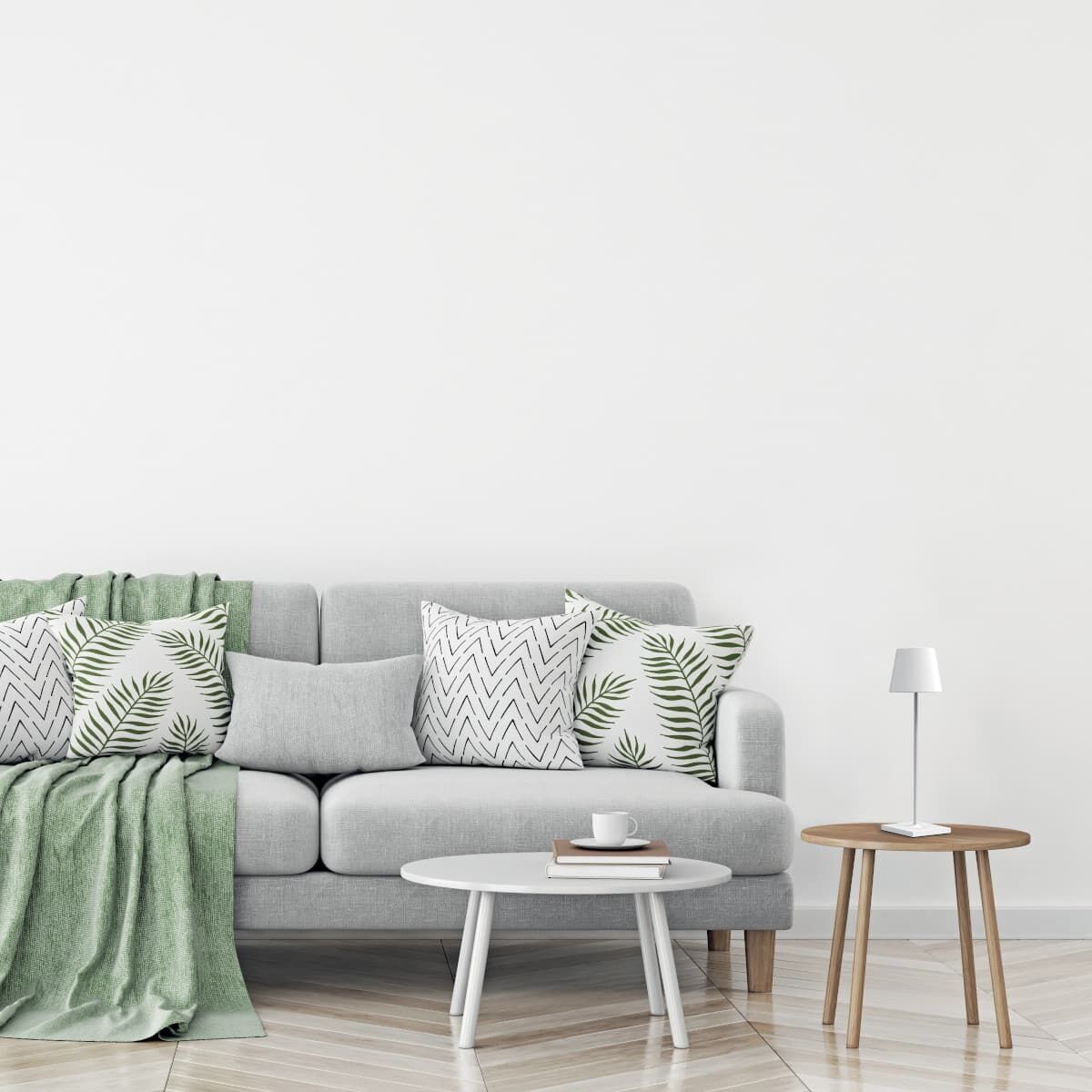Modernes Wohnzimmer mit grauem Sofa, bequemen Kissen mit Palmenmustern, einem weißen runden Beistelltisch mit Tasse und Buch und einer LED-Tischlampe »Poldina Pro« auf einem Holztisch.