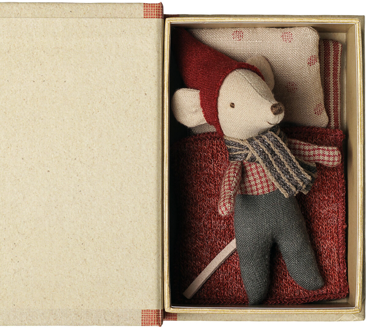 Im Bild ist das Maileg Kuscheltier »Weihnachtsmaus-Baby in Buch« zu sehen. Die kleine Maus liegt in einer als Buch gestalteten Schachtel auf roter Decke, trägt Weihnachtsmütze, kariertes Hemd, Schal und dunkle Hose. Der Hintergrund ist neutral gehalten.
