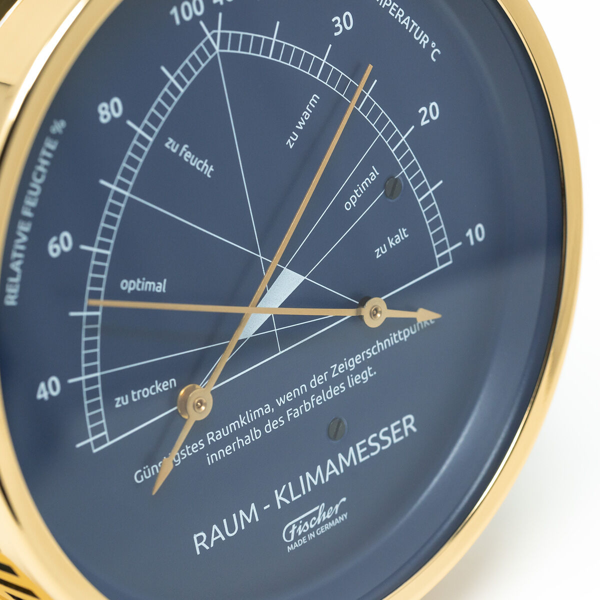 Rundes Messgerät mit blauer Anzeige und goldfarbenem, poliertem Messingrahmen. Das Gerät zeigt Temperatur und relative Luftfeuchte für optimales Raumklima an. Beschriftung in deutscher Sprache mit Skalen für Feuchtigkeit und Temperatur. Elegantes Design für Wohn- und Arbeitsbereiche.