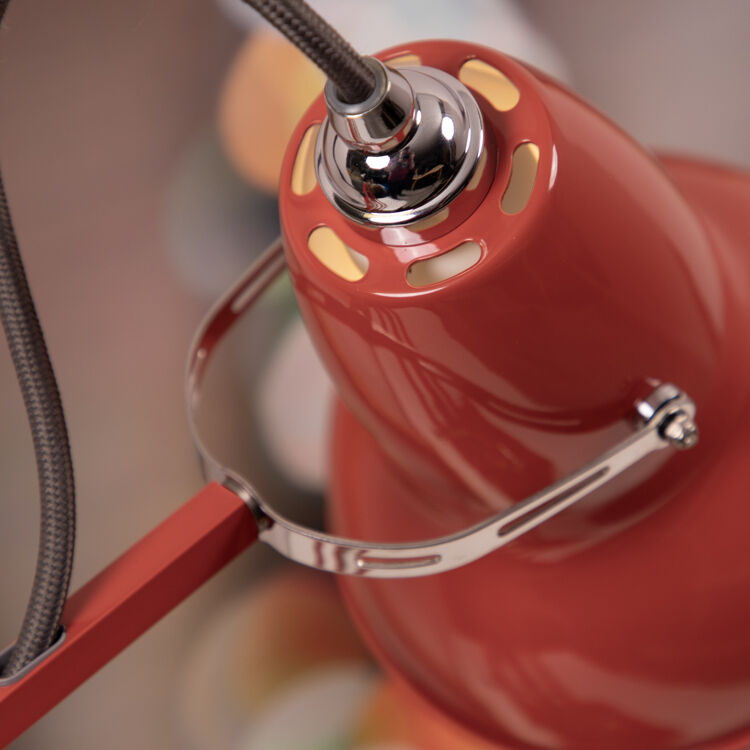 Nahaufnahme einer roten Tischleuchte aus der ZEIT-Sonderedition »Anglepoise Original 1227». Die Lampe zeigt glänzende Metallteile und ein robustes, industrielles Design.