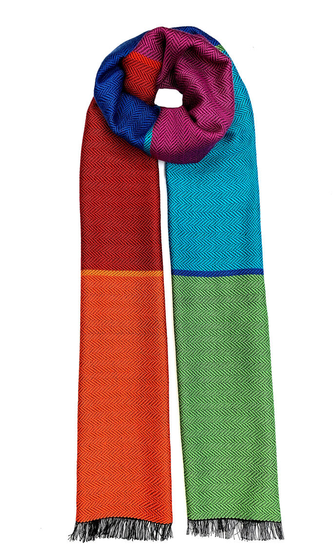 Ein bunter Seidenschal mit Fischgratmuster in den Farben Rot, Orange, Blau, Grün und Lila, mit schwarzen Fransen an den Enden.