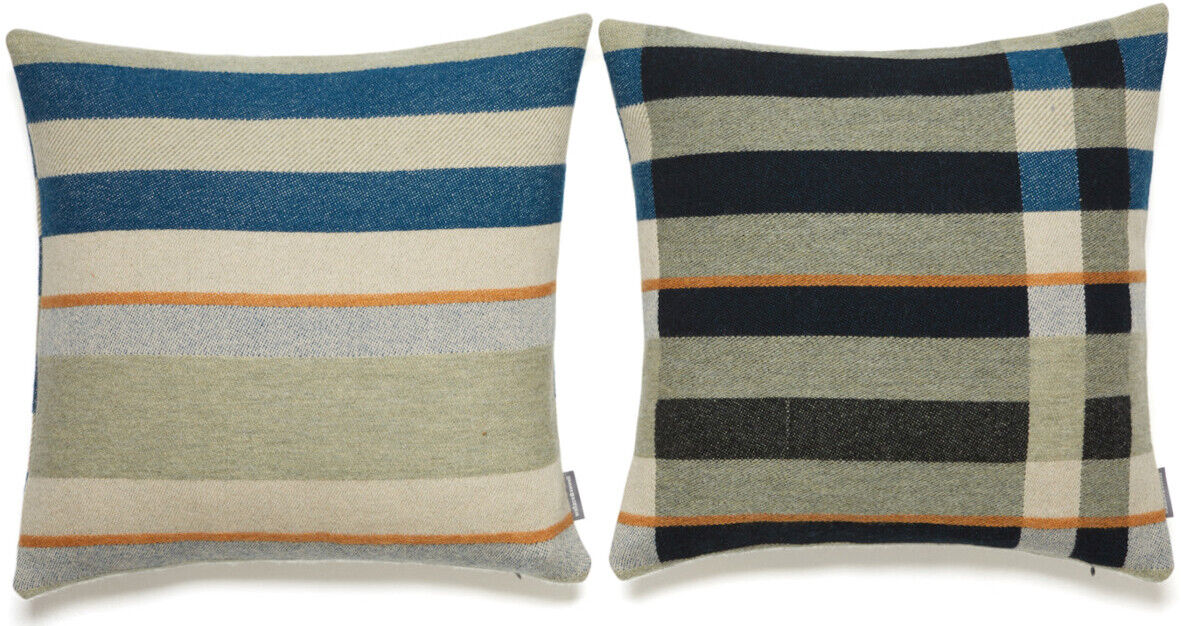 Zwei Kissen im Bauhaus-Stil nebeneinander. Beide haben geometrische Muster in Blau, Beige, Schwarz, Weiß und Orange.