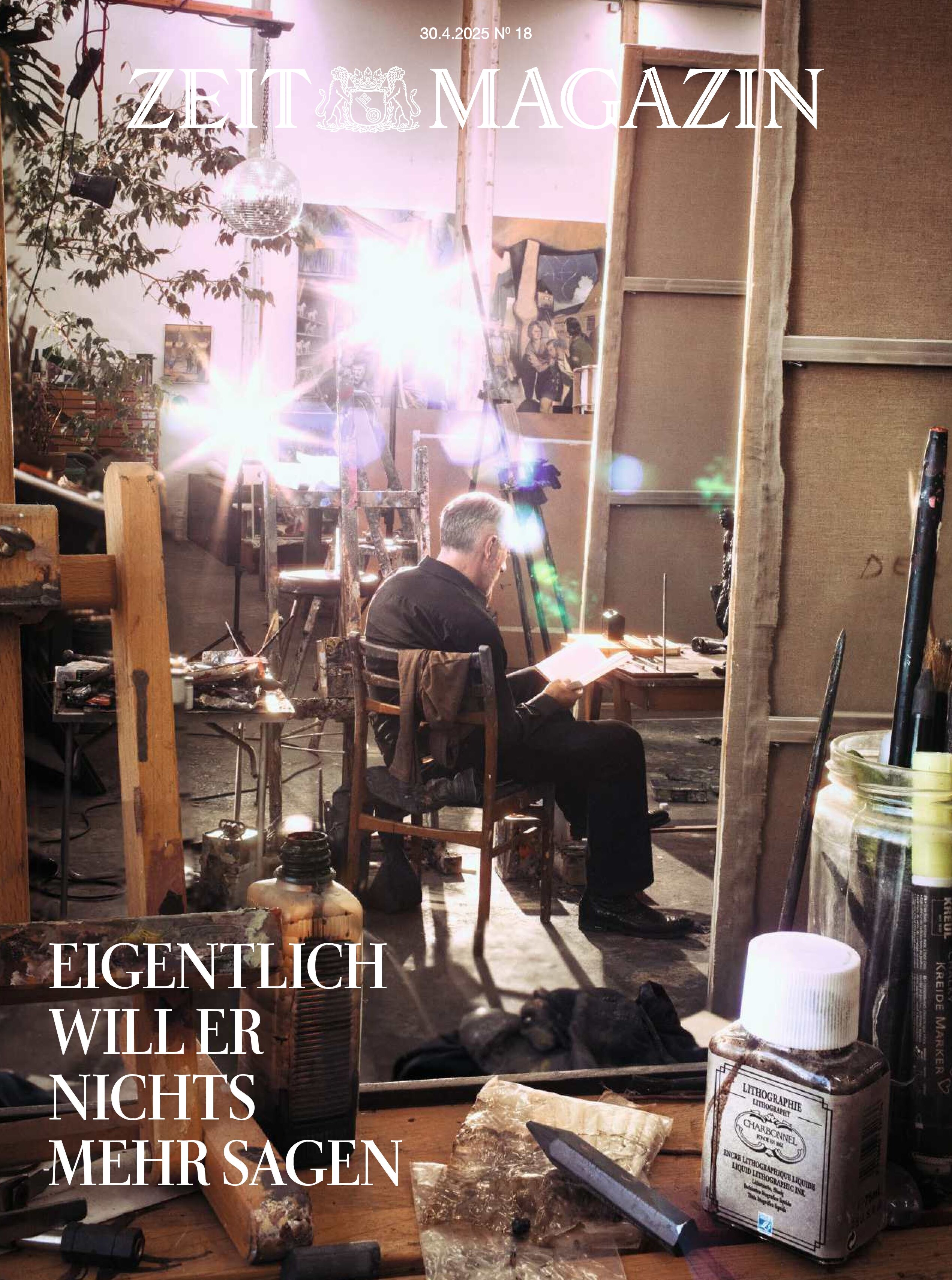Ein Mann sitzt in einem Künstleratelier auf einem Holzstuhl, umgeben von Kunstmaterialien. Er scheint zu lesen oder zu schreiben. Im Vordergrund sind diverse Malutensilien und Fläschchen zu sehen. Es herrscht eine ruhige, kreative Atmosphäre. Das Cover der Zeitschrift 'ZEIT Magazin' zeigt den Titel und eine Schlagzeile 'Eigentlich will er nichts mehr sagen'.
