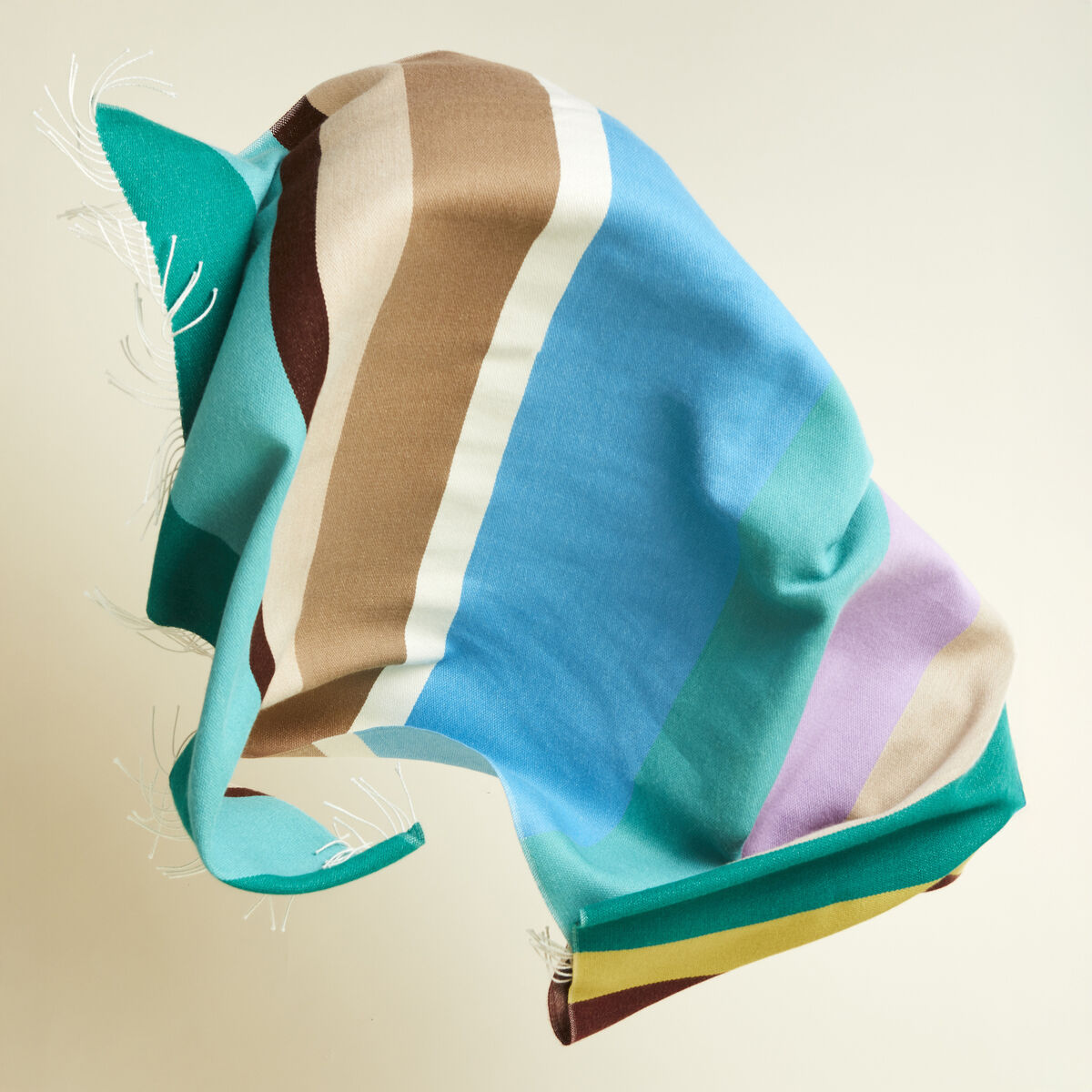 Das Cape »Mainau« von parati ist aus 100 % Alpaka, zeigt breite Farbblöcke in Türkis, Grün, Gelb, Bordeaux und Pastell. Es ist großzügig geschnitten, hat Fransen und wirkt edel, weich und modern – ideal als farbenfrohes, luxuriöses Statement-Accessoire.