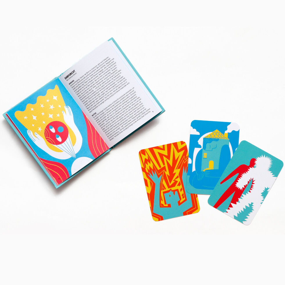 Ein aufgeschlagenes Buch mit bunten Illustrationen und drei Karten, die ebenfalls lebhafte Zeichnungen tragen. Das farbenfrohe Design spricht Gefühle und Selbstreflexion an.