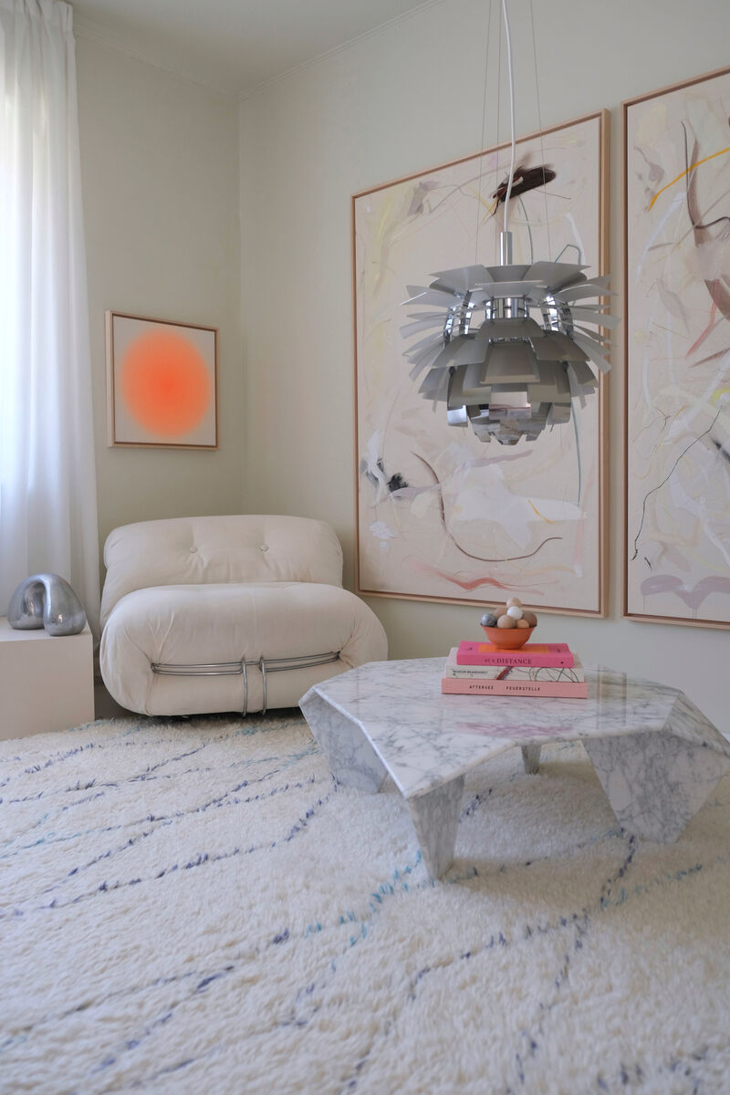 ZEIT-Sonderedition Sorbet »Orange II« (50x50cm) eingerahmt an einer Wand in einem modernen, warm dekorierten Wohnzimmer mit einem gemütlichen Sessel, zwei großen Kunstwerken und einem stilvollen Couchtisch.