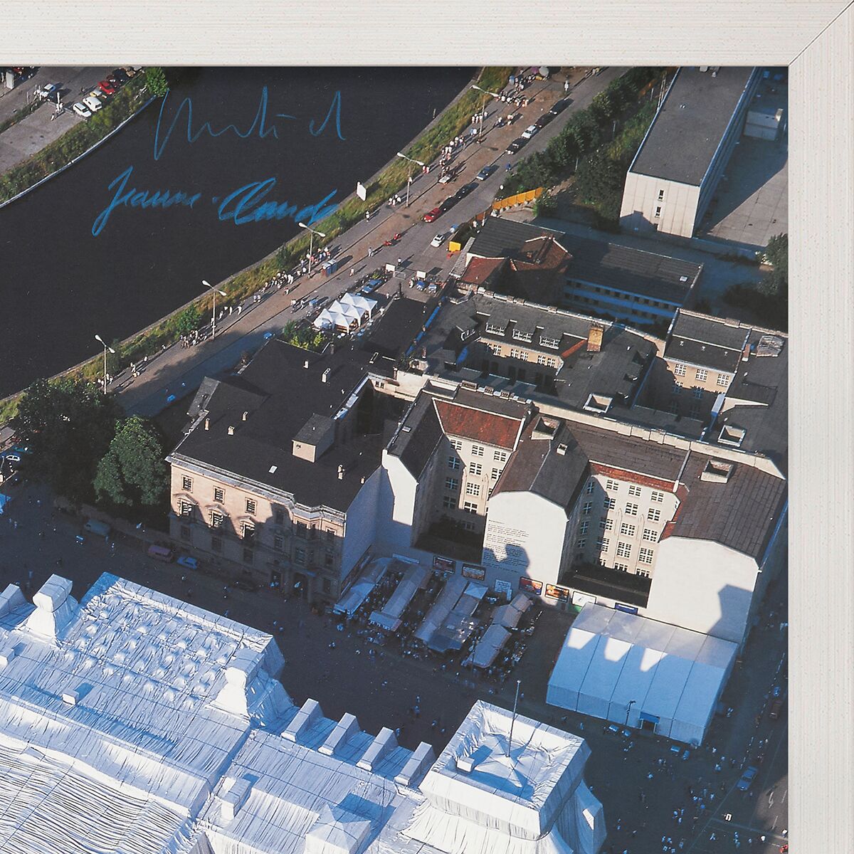 Luftaufnahme des Reichstags in Berlin, aus Westen nach Osten fotografiert. Zu sehen sind umliegende Gebäude, Straßen und Grünflächen. Eine gerahmte Fotografie, geeignet für Kunstsammler und Geschichtsinteressierte.