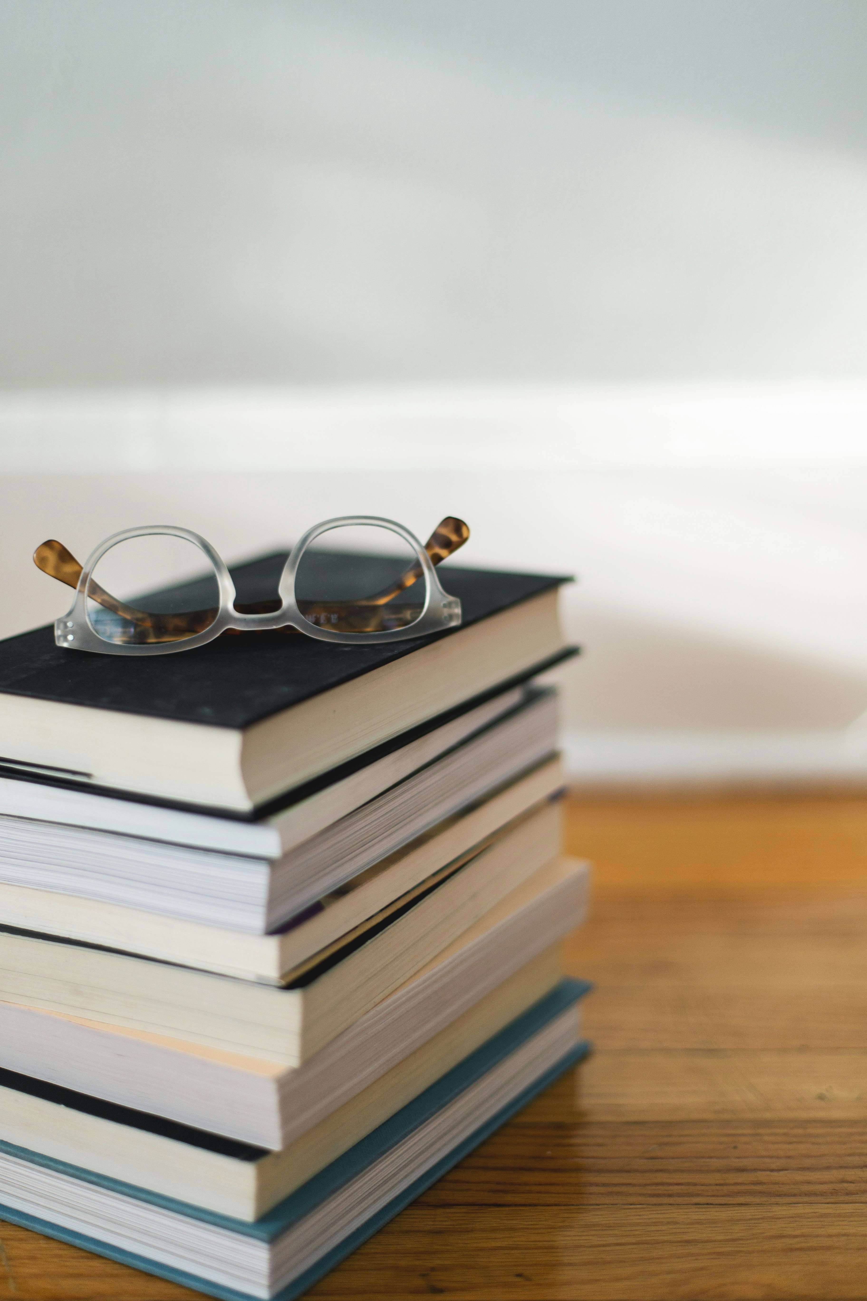 alt="Bücherstapel mit einer Brille darauf – Bild zur Kategorie Sachbücher"