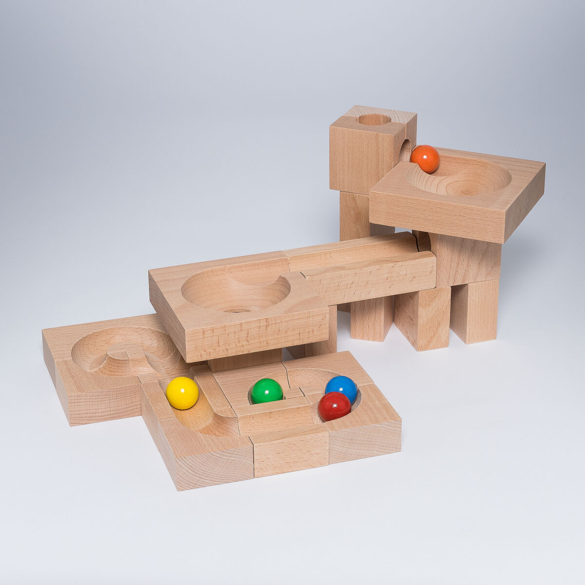 Ein Holz Kugelbahn-Spielzeug mit natürlicher Holzoberfläche und bunten Kugeln in den Farben Orange, Gelb, Grün, Rot und Blau. Geeignet für Kinder und zur Förderung von Kreativität und Motorik.