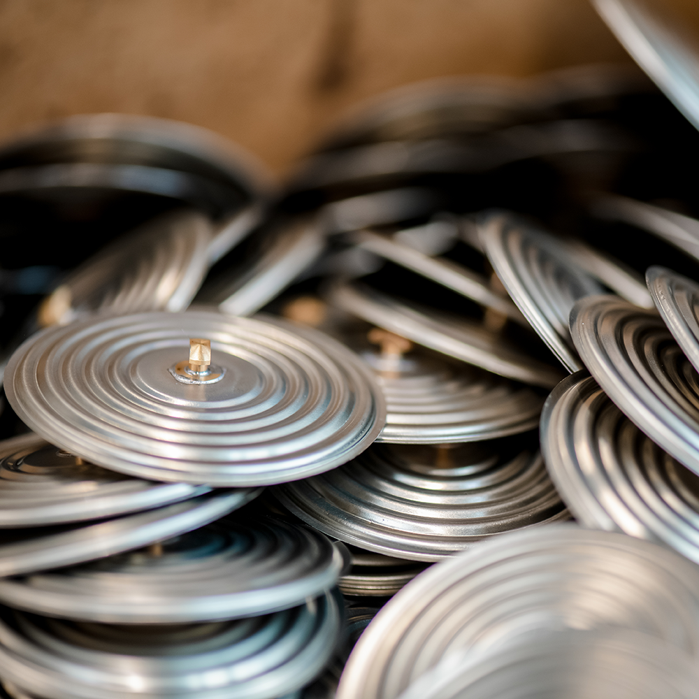 Viele silberne Metallspiralen mit zentralem Stift, gestapelt in einem Behälter