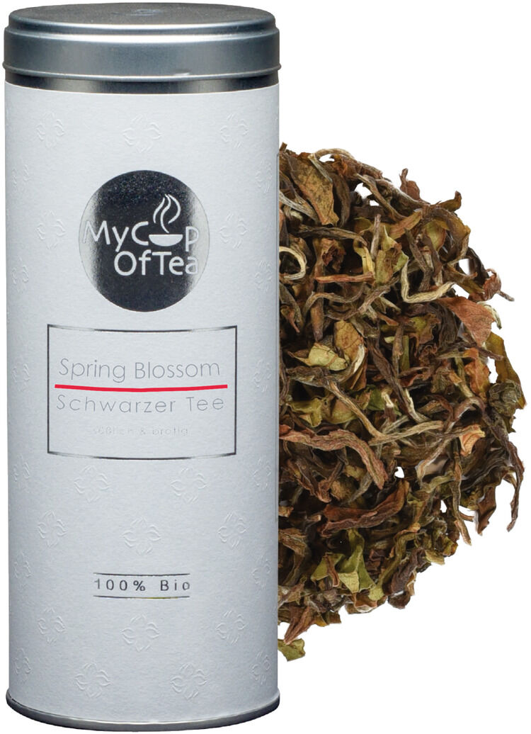 Das Bild zeigt eine weiße Teedose mit der Aufschrift 'My Cup of Tea Spring Blossom Schwarztee 100% Bio', daneben lose Teeblätter in verschiedenen Brauntönen.