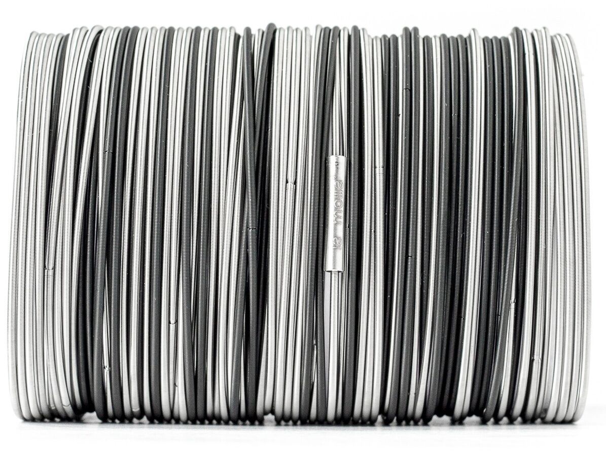 Das Bild zeigt das la molla Armband »Salz und Pfeffer Black«, bestehend aus zahlreichen parallel angeordneten Edelstahlfedern in Silber und Schwarz. Das elastische Armband wirkt kontrastreich, minimalistisch und hochwertig. Ein kleines graviertes Edelstahlröhrchen ist sichtbar.