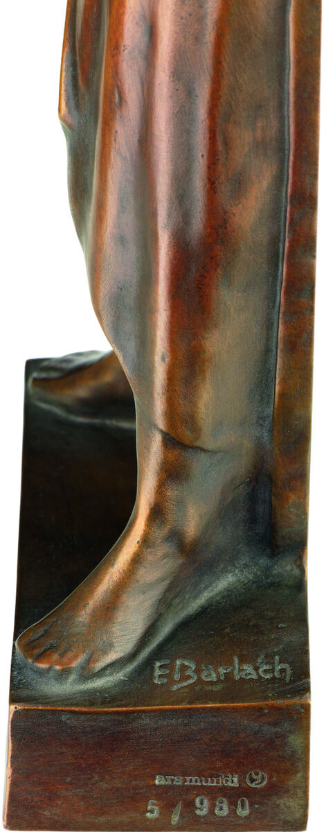 Ausschnitt einer Bronze-Skulptur von Ernst Barlach, deutlich sichtbar der Fußbereich auf eckigem Sockel. Auf dem Sockel befinden sich die Signatur „E. Barlach“ sowie Prägungen und eine Nummerierung. Die Oberfläche ist strukturiert, patiniert und poliert, warm bronzefarben.