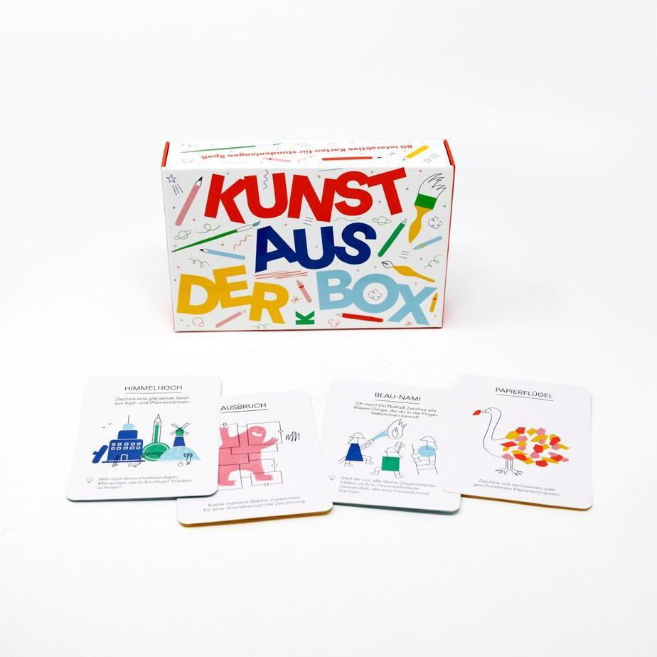 Verpackung des Spiels 'Kunst aus der Box' mit vier illustrierten Spielkarten davor. Bunt gestalteter Karton mit den Worten 'Kunst aus der Box'.