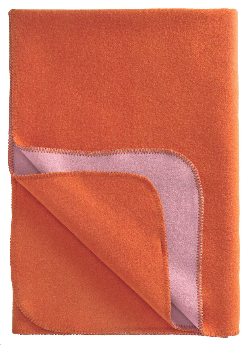 Die Merinowolldecke »DUO« von Eagle Products ist in kräftigem Orange mit einer Rückseite in Rosé-Lila gehalten. Die weiche, moderne Decke aus 100% Schurwolle zeigt ein dezentes Karo-Design und eine feine Umrandung, ideal als hochwertiges Wohnaccessoire.