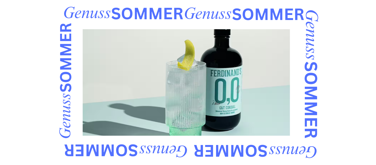Klares Getränk mit Zitronenscheibe neben Flasche Ferdinand's 0,0 Dry Gin auf hellem Untergrund